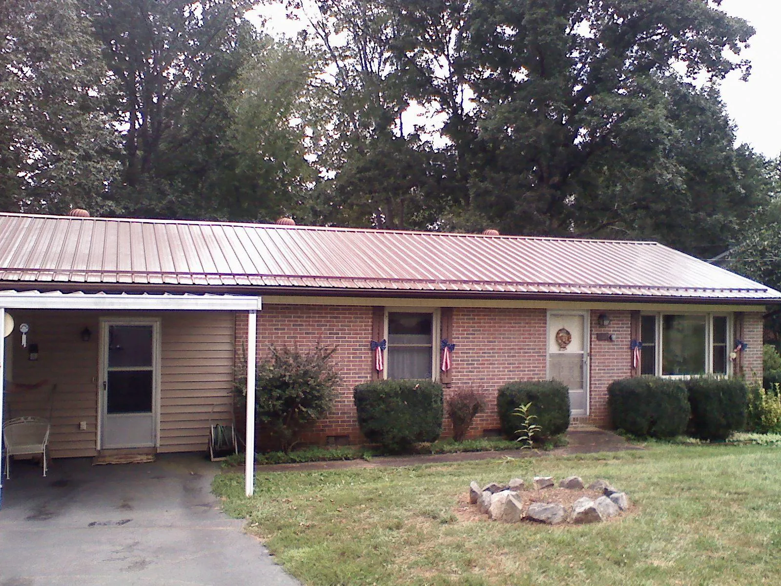 Bronze metal roof and carport on a brick ranch home — Roof Repair work by our crew in Rayle